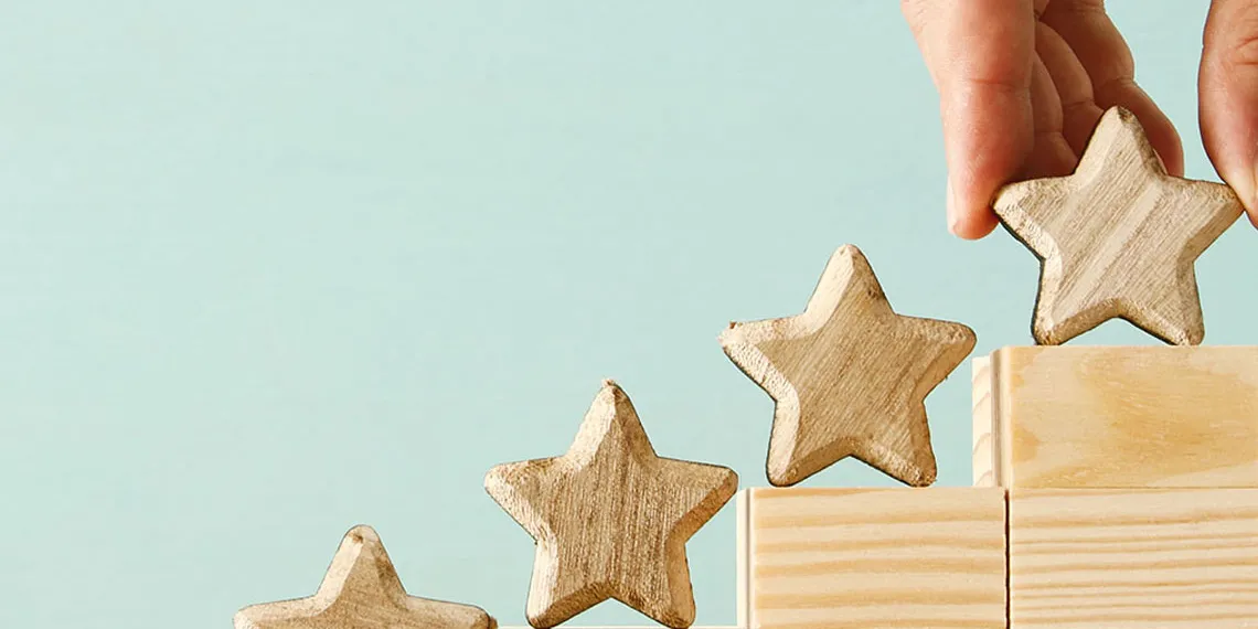 A wooden stair that goes from the lowest to the highest step, having wooden stars on each of the five steps.