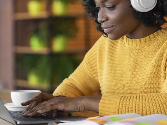  A female student goes over her online course session on her personal computer. 