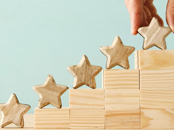 A wooden stair that goes from the lowest to the highest step, having wooden stars on each of the five steps.