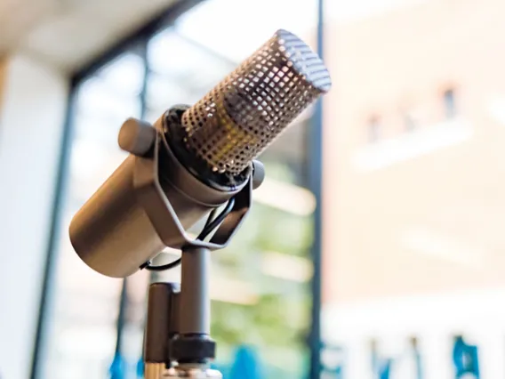 A close-up of a professional podcast studio microphone.