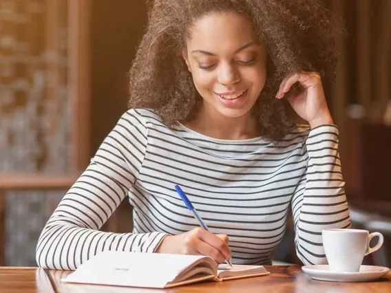 An instructor is writing measurable learning outcomes in her notepad.