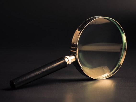 Golden magnifying glass on a dark background.