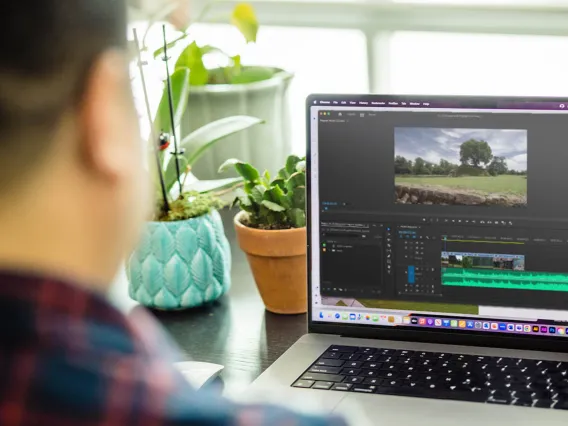 A faculty member observes his Adobe Premiere Pro class project on his laptop, seeking a more reliable editing method.