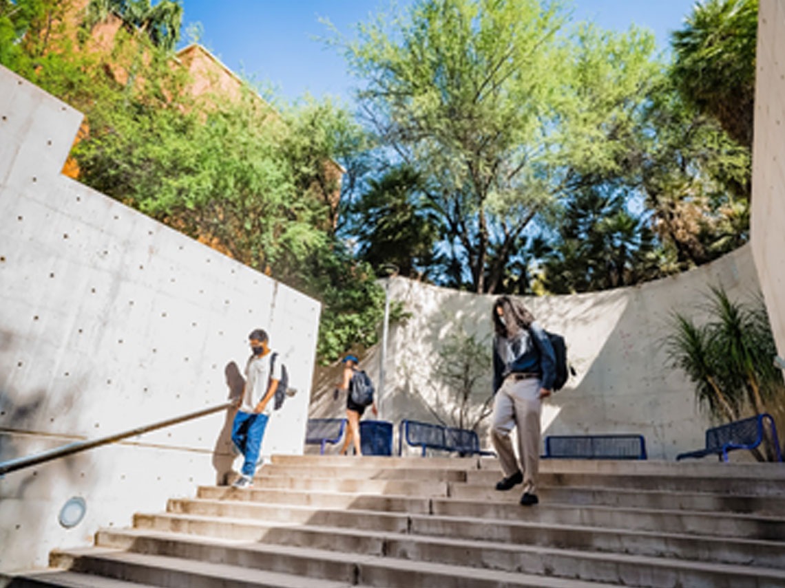 A couple of UArizona students are walking down the stairway towards the Manuel Pacheco Integrated Learning Center (ILC).