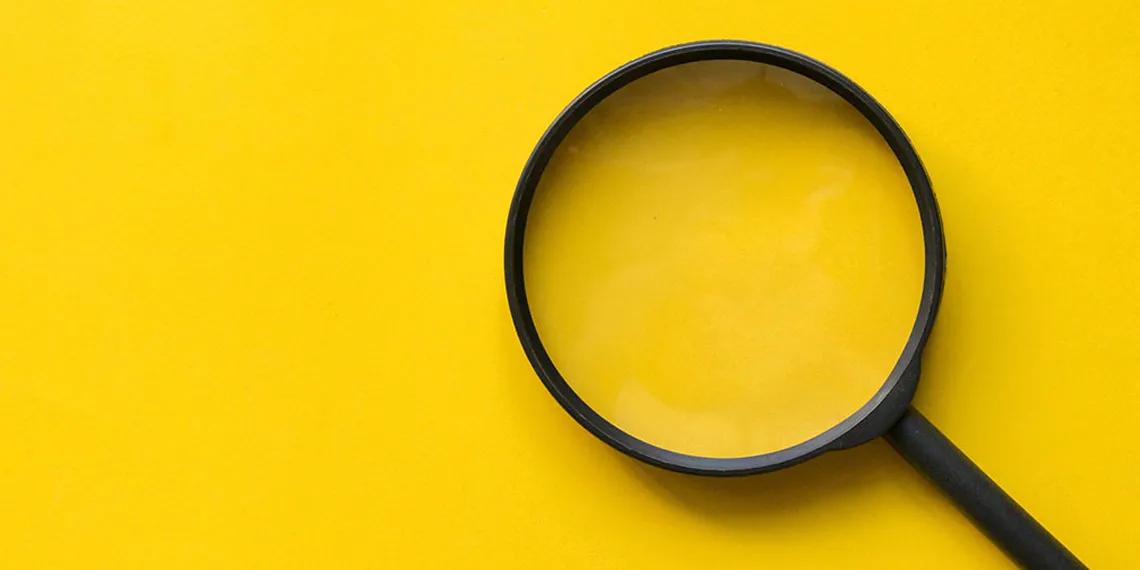 Black magnifying glass on a yellow background.