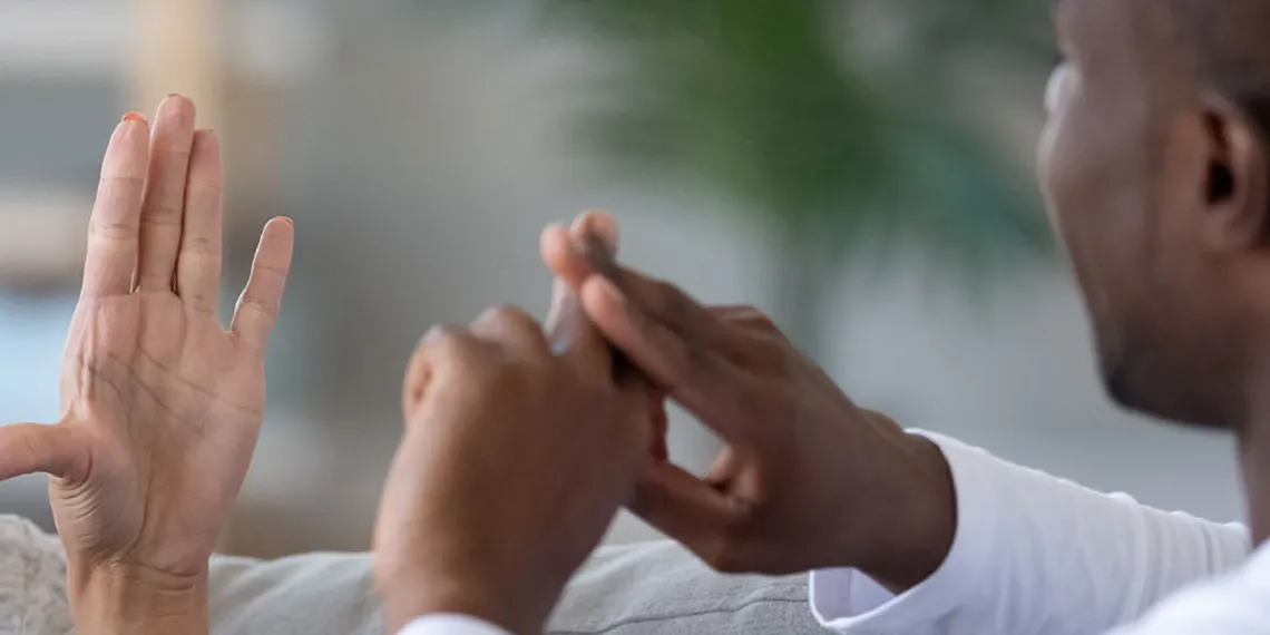 A couple people are communicating via sign language.