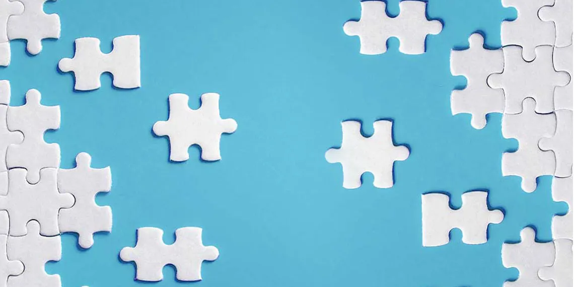 An all white puzzle sits on a light blue background.