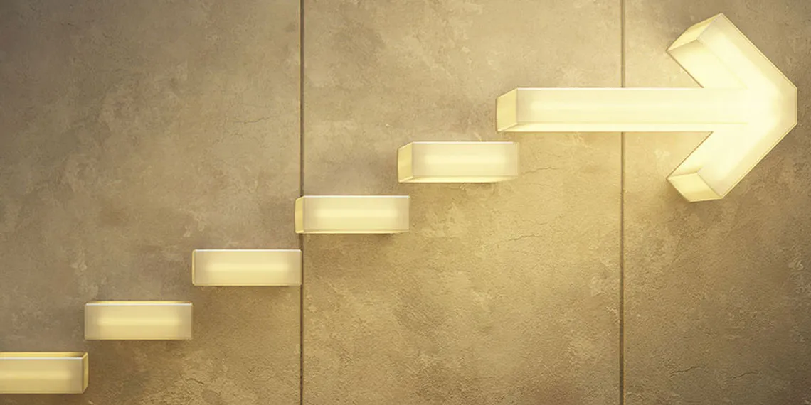 A staggered lit arrow light is mounted on a concrete wall.