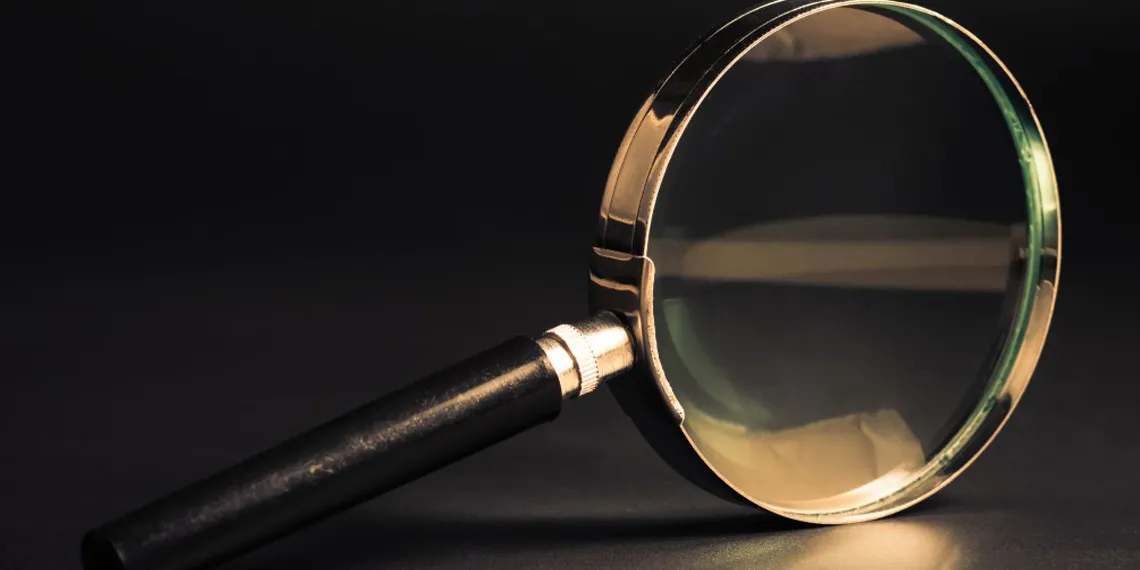 Golden magnifying glass on a dark background.