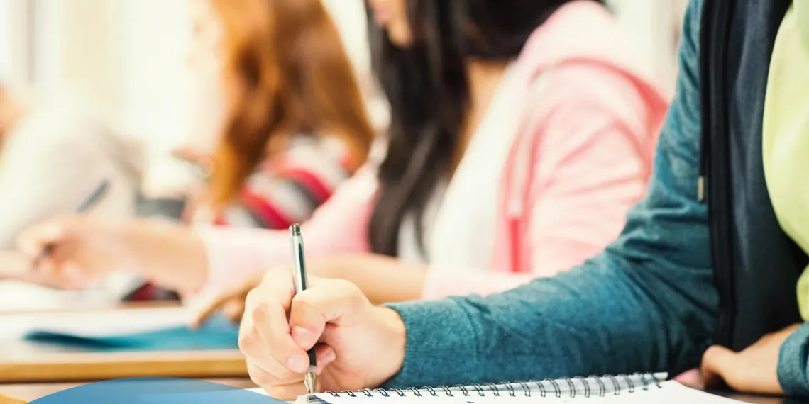 Students writing with pen and paper